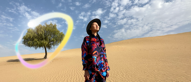 iPad Pro, écran face avant avec fond dégradé bleu foncé et vert et plusieurs apps ouvertes, main tenant un Apple Pencil Pro encerclant un croquis et illustrant la fonctionnalité baguette graphique d’Apple Intelligence